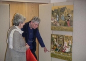 Team member Gill Winfiled pointing out embroidery detail to a visitor